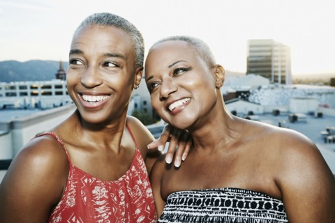Black women smiling on urban rooftop