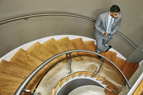 High angle view of Middle Eastern businessman standing on spiral staircase