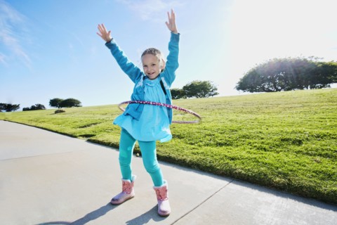 Mixed race spinning plastic ring on sidewalk
