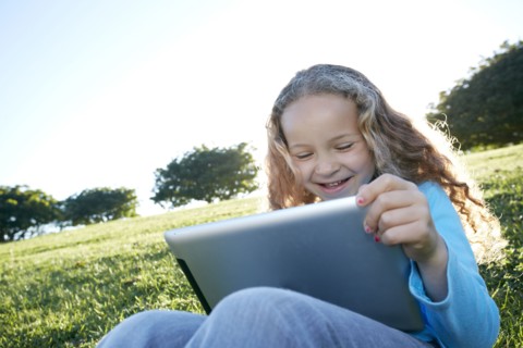 Mixed race girl using digital tablet in field