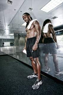 African American man standing at mirror in gym