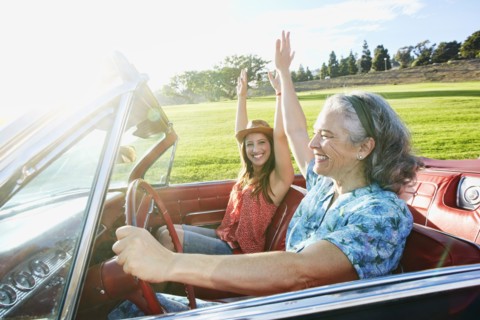 Mother and daughter driving in classic convertible