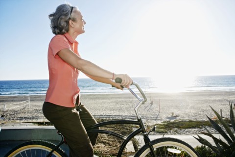 Caucasian woman riding bicycle near beach