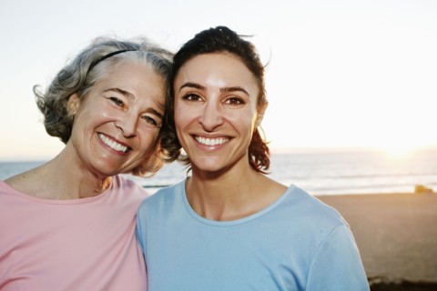 Caucasian mother and daughter hugging at beach