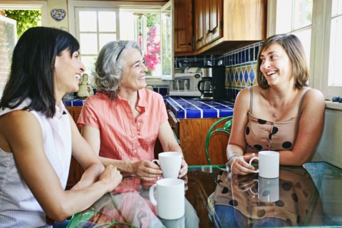 Caucasian mother and daughters drinking coffee in kitchen