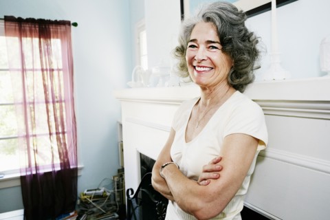 Caucasian woman standing with arms crossed in living room