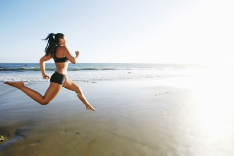Mixed race woman running on beach