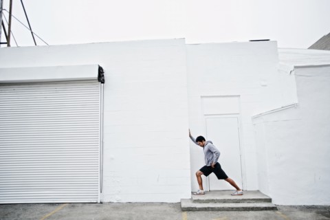 Mixed race man stretching in doorway