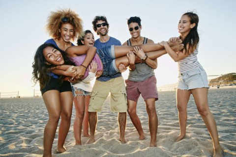 Smiling friends posing together on beach