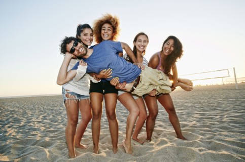 Smiling friends posing together on beach