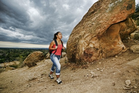 Hispanic woman hiking on rocky hillside