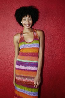 Smiling black woman standing near red wall