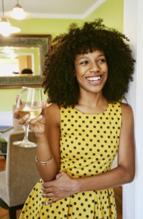 Mixed race woman drinking glass of white wine