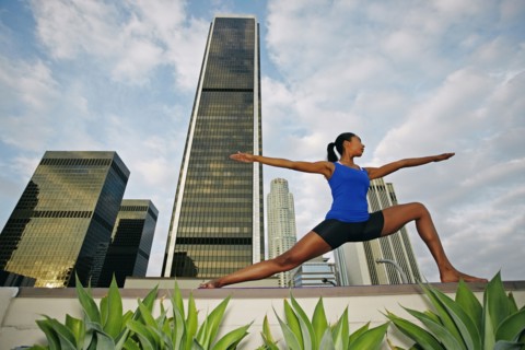 African American woman practicing yoga on urban rooftop
