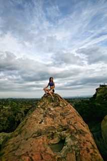 Vietnamese woman sitting on rocky hilltop