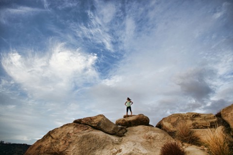 Vietnamese woman standing on rocky hilltop