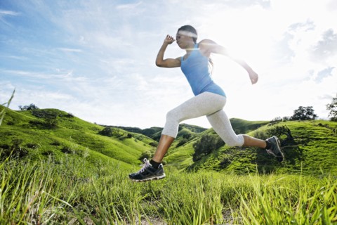 Black athlete running on rural hilltop