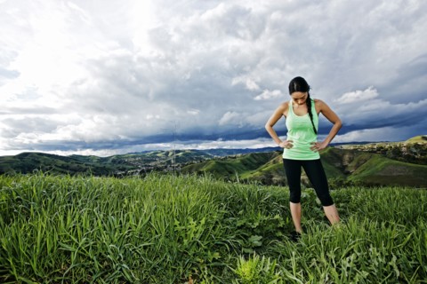 Mixed race athlete standing on rural hilltop
