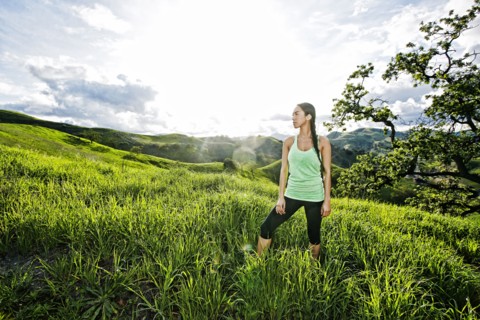Mixed race athlete standing on rural hillside