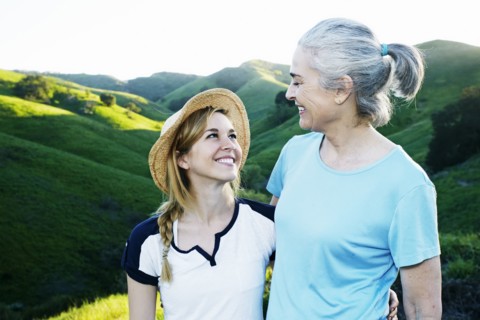 Caucasian mother and daughter smiling on rural hilltop