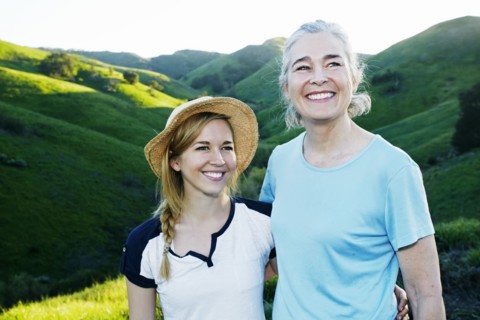 Caucasian mother and daughter smiling on rural hilltop
