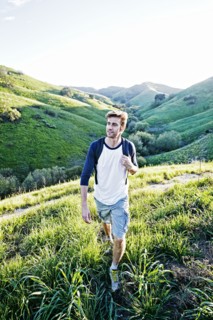 Caucasian man walking on rural hillside