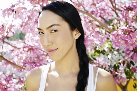 Mixed race woman standing under flowering tree