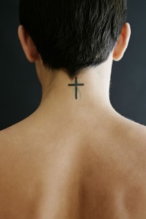 Hispanic woman with crucifix tattoo on neck