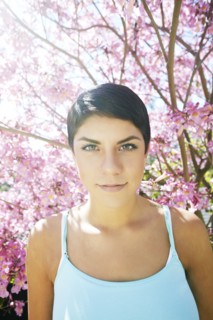 Hispanic woman standing under flowering tree