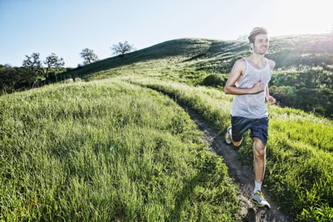 Caucasian athlete running on rural trail