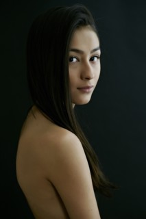 Nude Hispanic woman looking over shoulder
