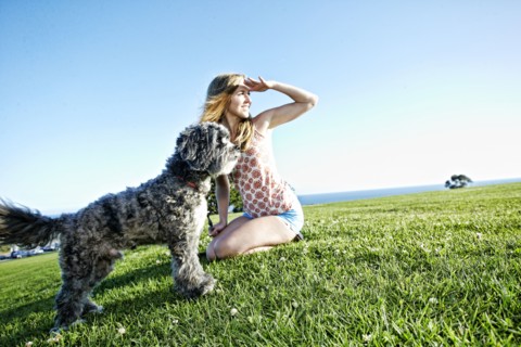 Caucasian woman sitting in field with dog