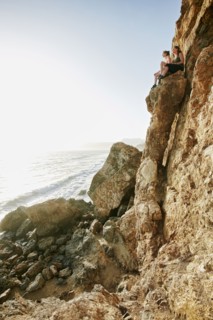 Women climbing rock formation