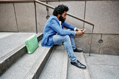 Mixed race businessman using cell phone