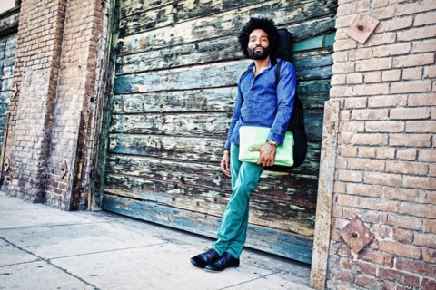 Mixed race musician carrying laptop outdoors