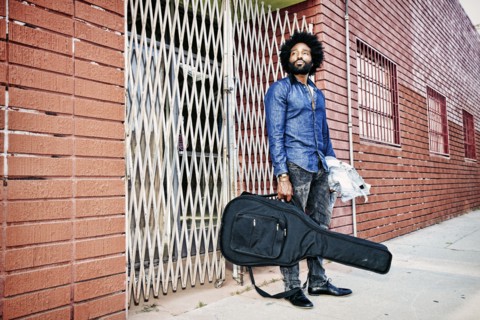 Mixed race man carrying guitar outdoors