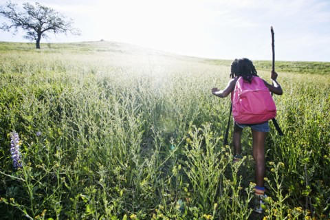 Black girl walking on rural hillside