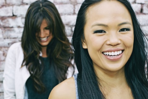 Women smiling at brick wall