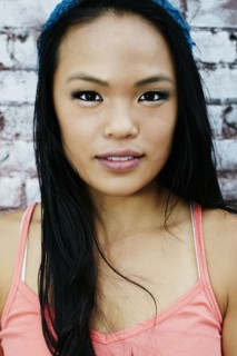 Serious Asian woman at brick wall