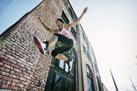 Mixed race woman jumping outdoors