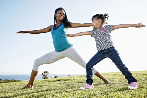 Black mother and daughter practicing yoga