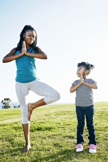 Black mother and daughter practicing yoga