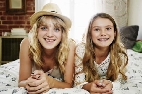 Mother and daughter smiling on bed