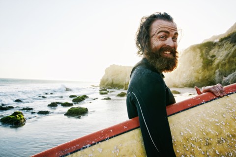Caucasian man holding surfboard at beach