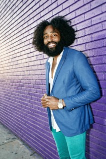 Mixed race man smiling outdoors near purple wall