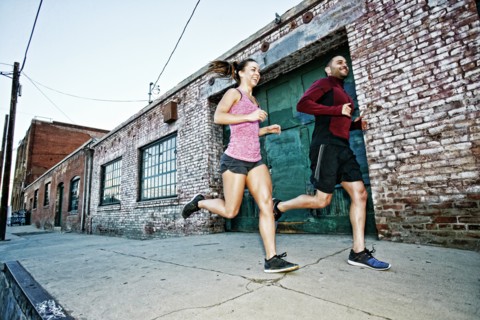 Caucasian couple jogging on sidewalk