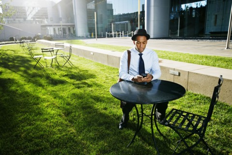 Black businessman using cell phone outdoors