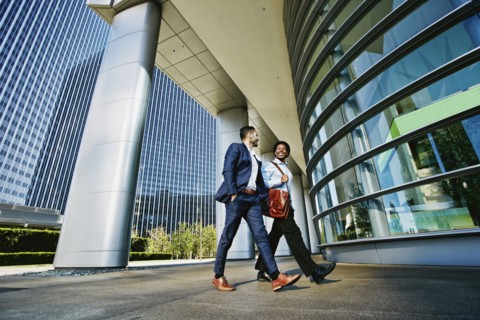 Businessmen walking outside office building