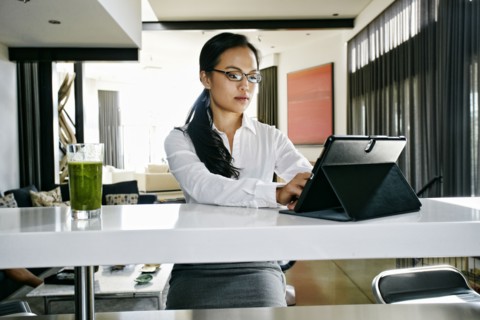 Chinese businesswoman using digital tablet at counter