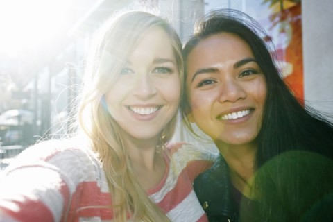 Close up of smiling women hugging outdoors